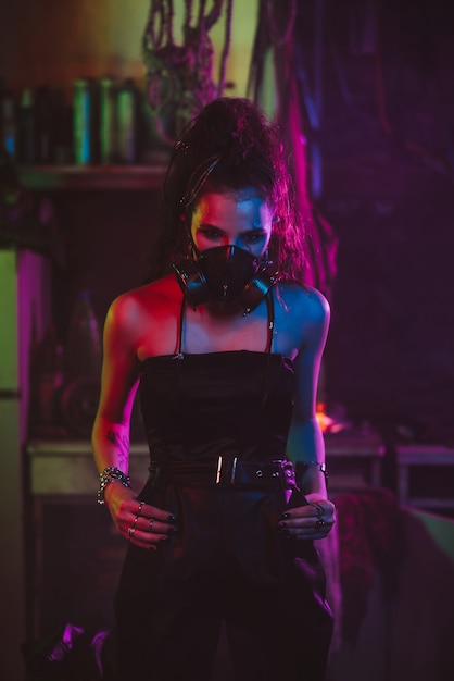 Girl in cyberpunk style in a gas mask suit with a neon light at\
night in the garage. steampunk cosplay