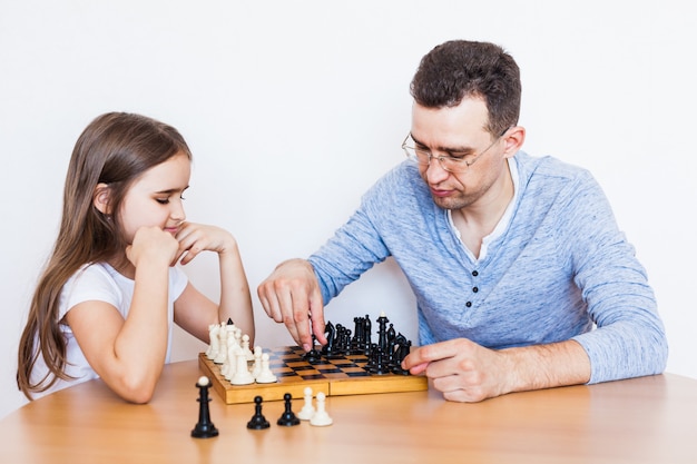 Girl and dad play a game at home, chess, puzzle for brain development, mental intelligence