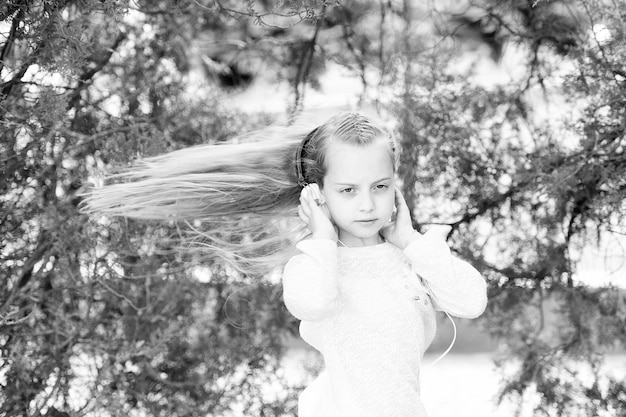 Girl dance to music in summer park small child enjoy music in
headphones outdoor kid dancer with long flying hair melody sound
and mp3 summer fun and joy