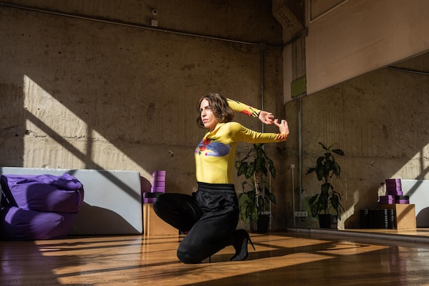 A girl dances a contemporary dance in a sunlit studio