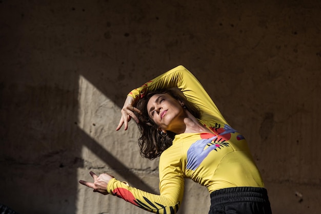 A girl dances a contemporary dance in a sunlit studio