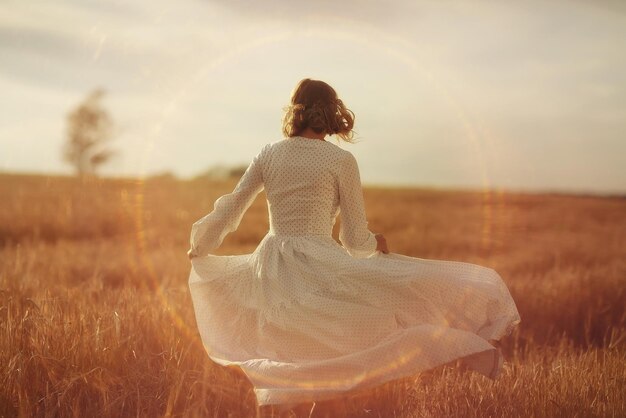 girl dancing in a field in white dress