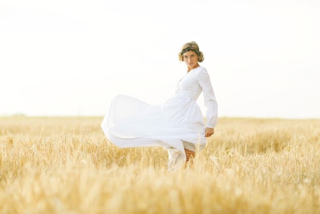 Girl dancing in a field in white dress