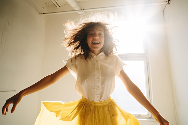 Photo girl dancing in front of a white wall wearing a yellow skirt and white blouse beautiful girl solo dance in white light in room