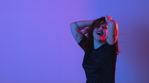 Ragazza che balla e si diverte alla festa. luce colorata, studio shot, copyspace