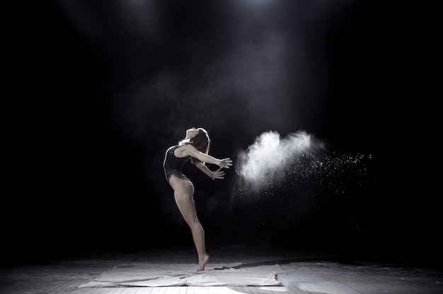 Girl dancing with a flour on black