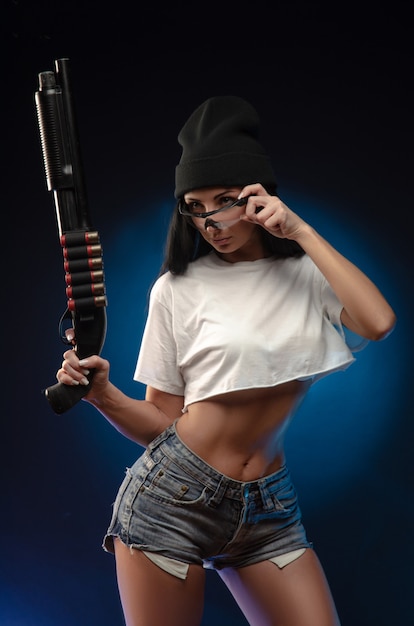Девушка на темном фоне с ружьем