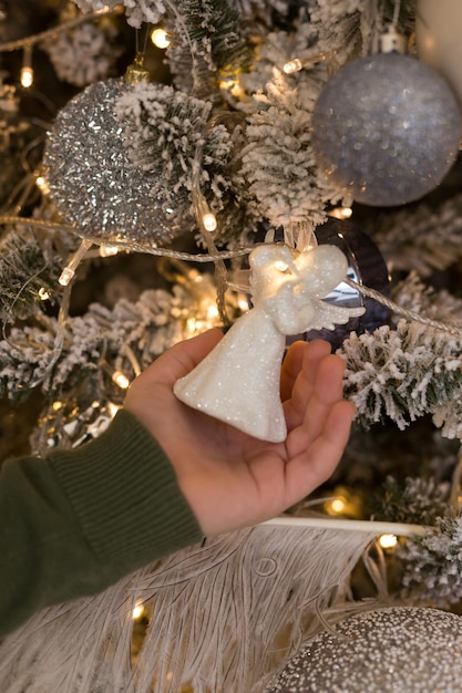 Girl decorating a Christmas tree. Christmas tree toy in hand