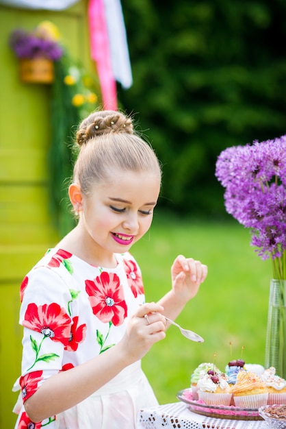 Girl decorating cupcakes in backyard