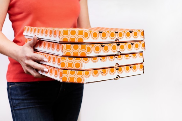 Girl delivering pizza in cardboard boxes on a white background