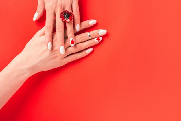 Girl demonstrates a white manicure with jewelry and a ring. Banner with empty place for text or invitation.