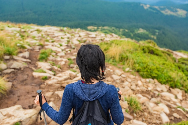 Girl descend down a large green mountain range