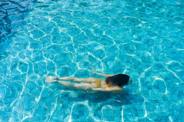 The girl dives under the water in the pool.