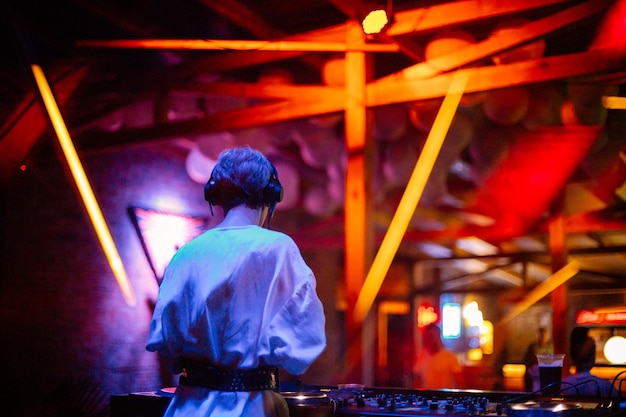 girl dj plays a set in a nightclub girl dj at the dj console against the backdrop of a nightclub