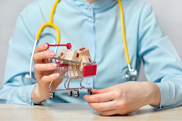 Girl doctor abstractly holds a shopping cart with abstract blocks with drugs