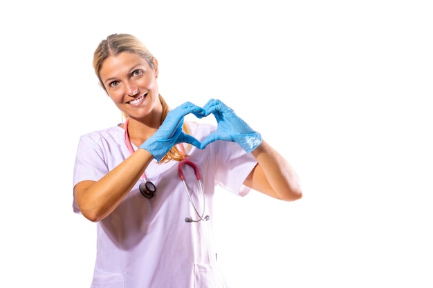 Девушка-врач формирует сердце руками и с улыбающимся лицом на белом фоне