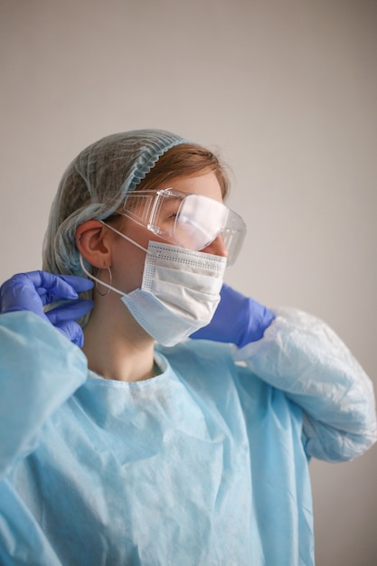 девушка-врач в защитном костюме и маске