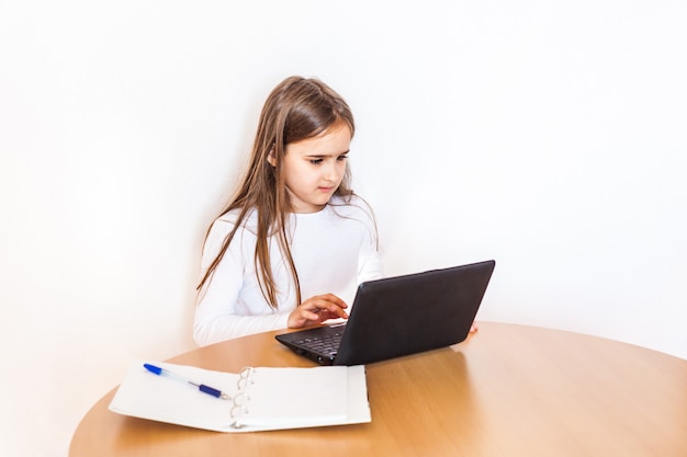 Foto la ragazza fa i compiti usando un computer laptot