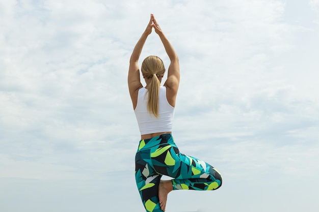 The girl does yoga in nature near the sea