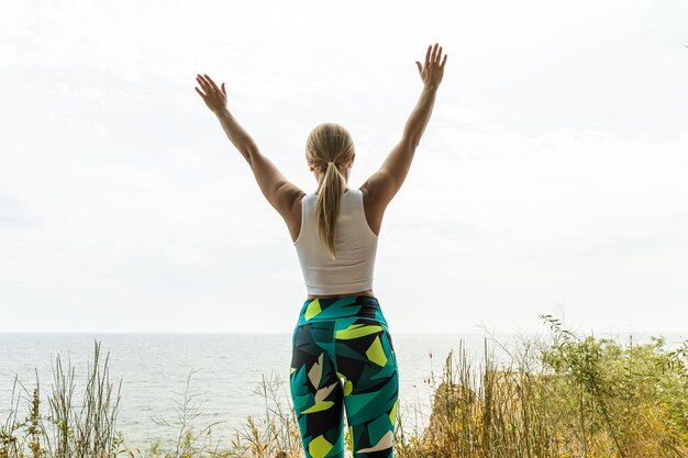 Photo the girl does yoga in nature near the sea