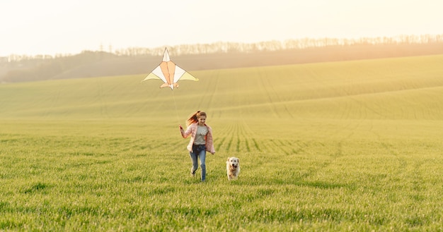 Girl and dog playing with kite