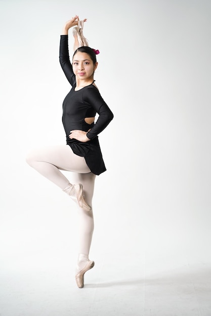 girl doing ballet in black costume on white background