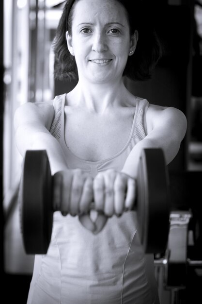 Photo girl doing exercise with 4 kg weights in the gym