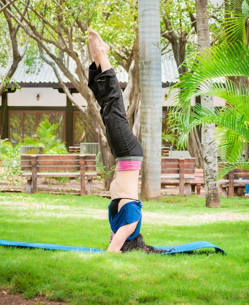 Girl doing headstand yoga woman doing yoga outdoors lifting feet up girl doing yoga with both legs up