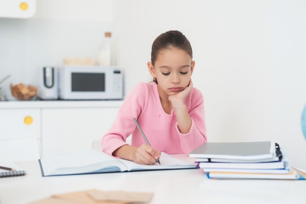 Girl doing homework in the kitchen.