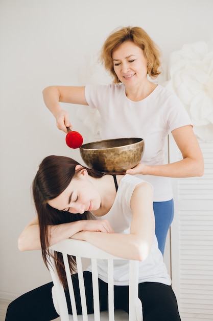 Girl doing massage therapy singing bowls in the Spa