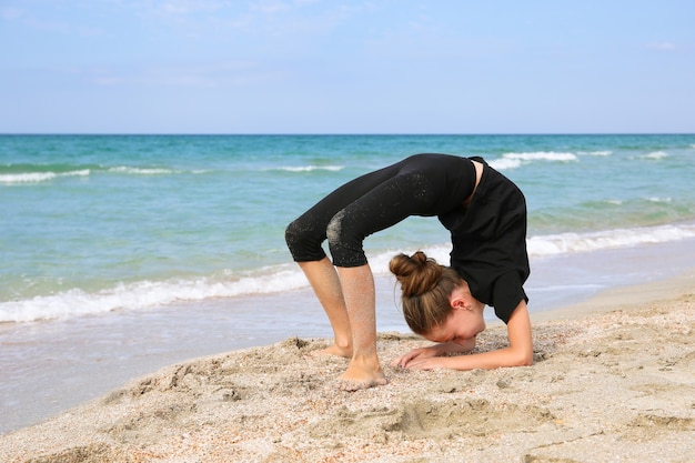 Girl doing sports exercises on the beach.