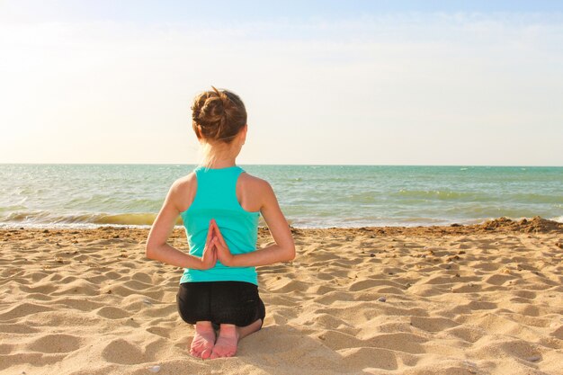 Girl doing sports exercises on the beach