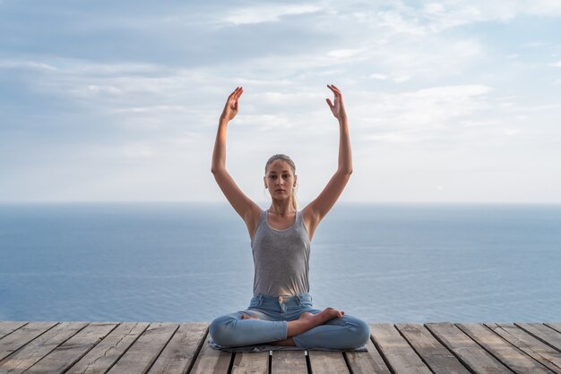 Girl doing yoga on the background of the sea