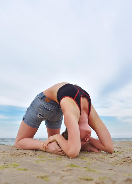 Girl doing yoga on coast