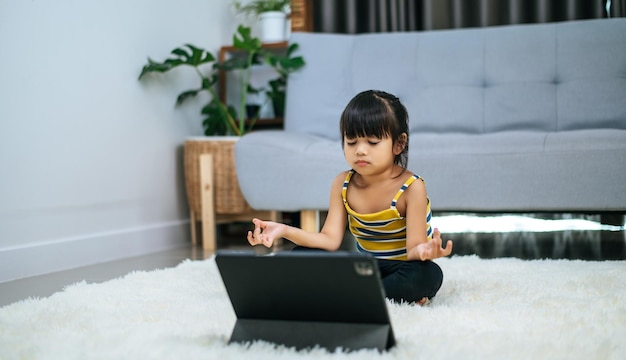 白いじゅうたんの上で部屋でヨガをしている女の子。セレクティブフォーカス。