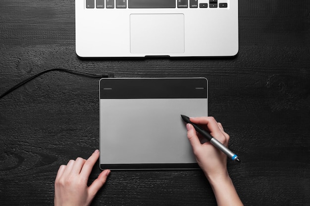 Girl draws on the black graphic tabletxAxA