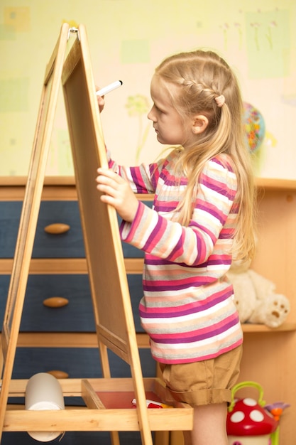 Girl draws on an easel