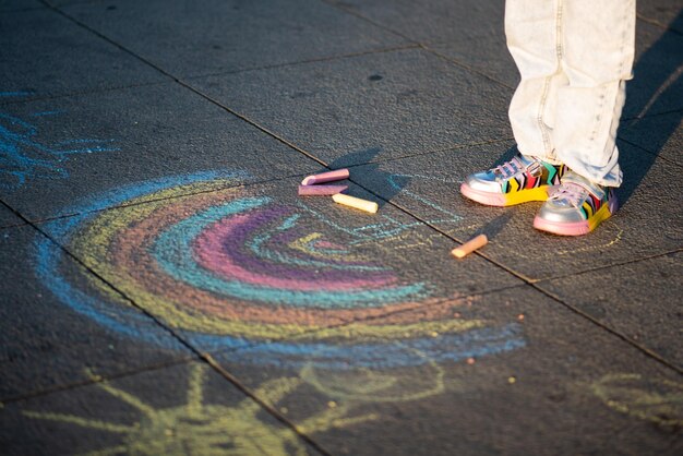 A girl draws a rainbow in the rays of the sunset