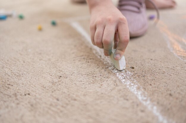 Girl draws with colorful crayons on pavement childrens drawings with chalk on wall creative kid joy