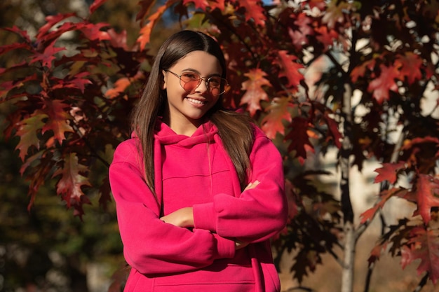 Girl dreams in autumn fall autumn mood of adolescent model autumn leaves in park outdoor girl portrait autumn teen girl wearing in sunglasses and looks stylish fall season warm clothes