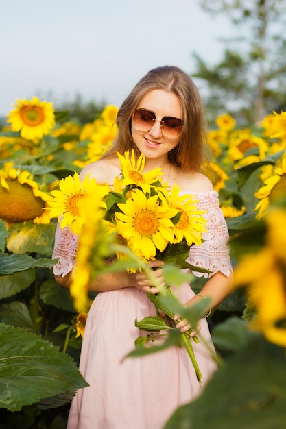 Ragazza in abito tra i girasoli, la ragazza si trova in un campo di girasoli