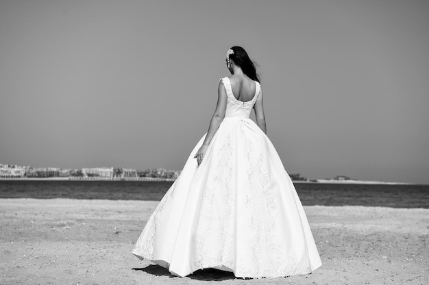 Девушка в платье на голубом небе у моря Женщина в белом платье Салон свадебной моды и красоты Невеста и свадебная церемония Элегантность и фотомодель