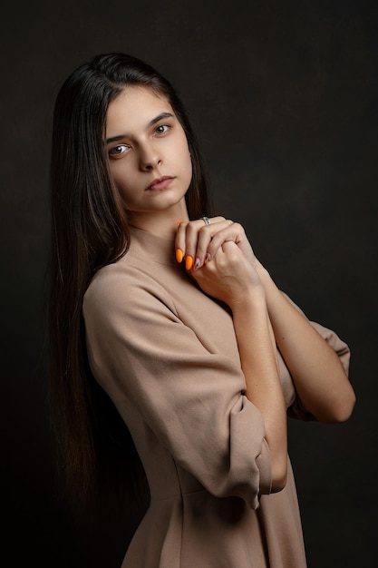 Foto una ragazza con un vestito su uno sfondo marrone