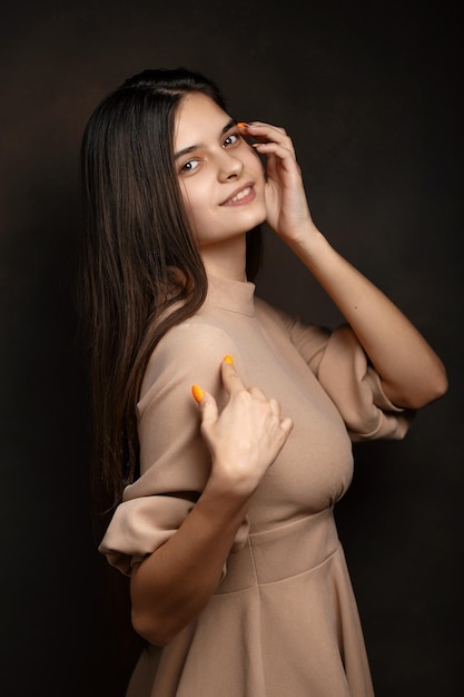 Photo a girl in a dress on a brown background