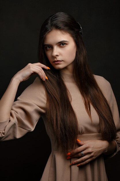 Photo a girl in a dress on a brown background