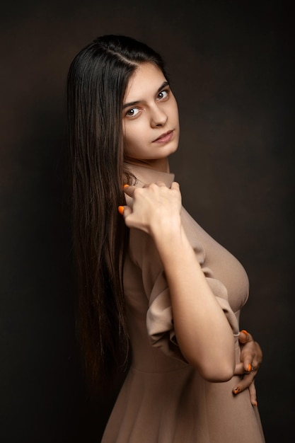 Photo a girl in a dress on a brown background