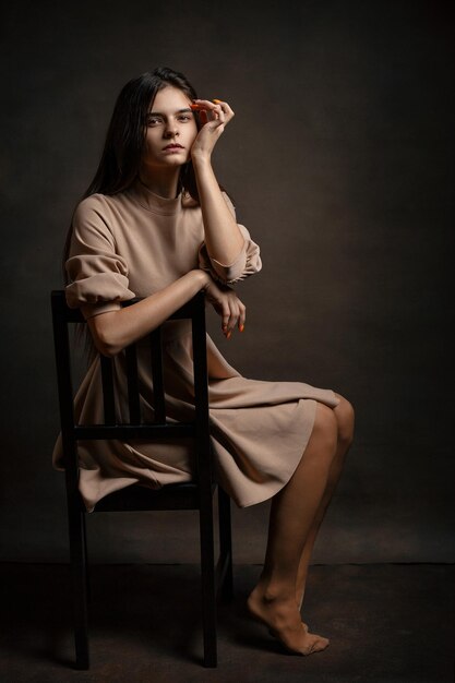 Photo a girl in a dress on a brown background