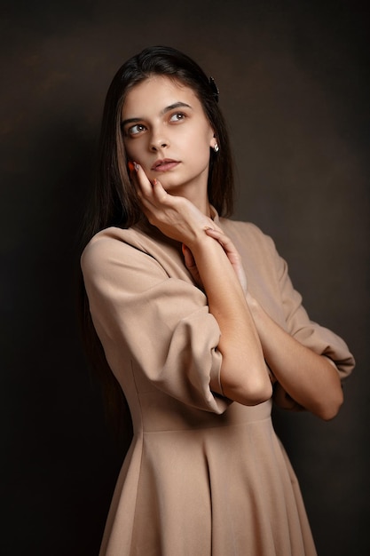 Photo a girl in a dress on a brown background