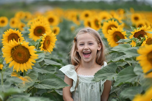 A girl in a dress enjoys life in a field with the sunflowers