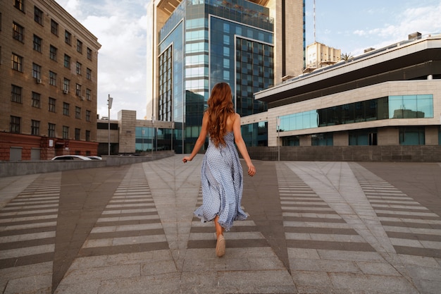 Photo girl in dress runs in the city. blurred